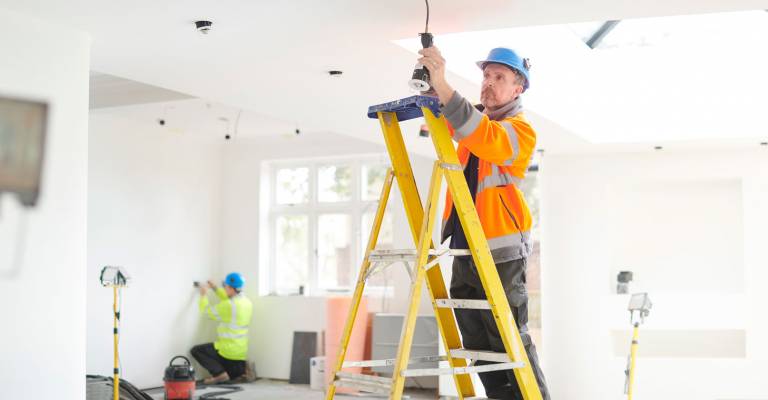 een elektricien is bezig met de bedrading in een huis